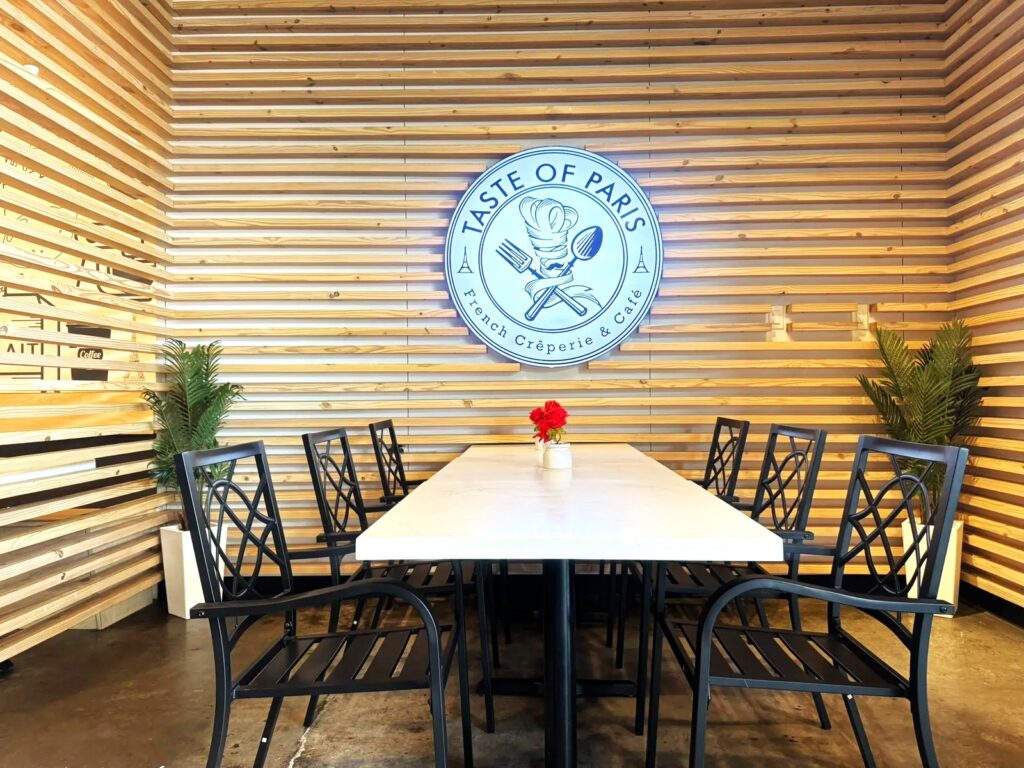 Large dining table beneath the Taste of Paris logo.